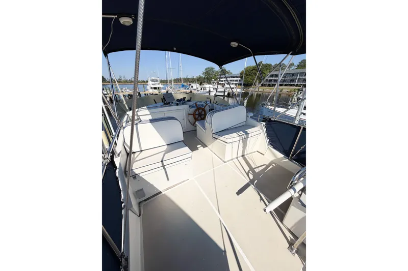 Slide: The Image of 1991 Grand Banks 36 Classic yacht deck with seating and steering wheel, docked at marina. - 13