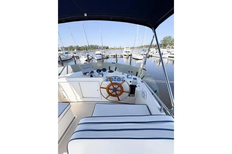 Slide: The Image of Helm of 1991 Grand Banks 36 Classic yacht docked at marina, featuring wooden steering wheel. - 18