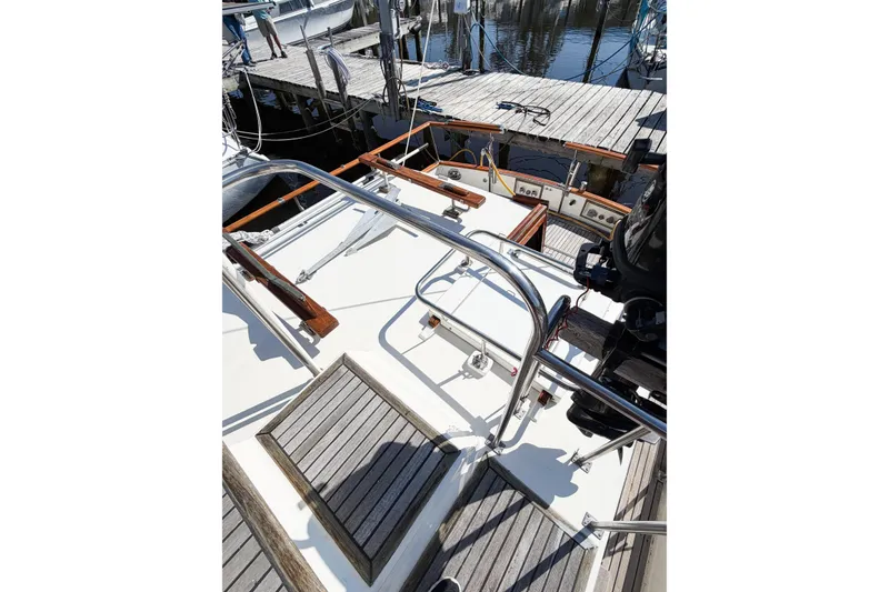 Slide: The Image of 1991 Grand Banks 36 Classic yacht deck with wooden accents and metal railings at a marina. - 25