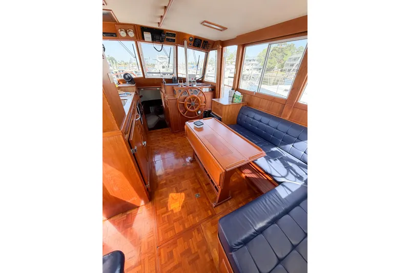 Slide: The Image of Interior of 1991 Grand Banks 36 Classic yacht with wooden furnishings and blue seating. - 31