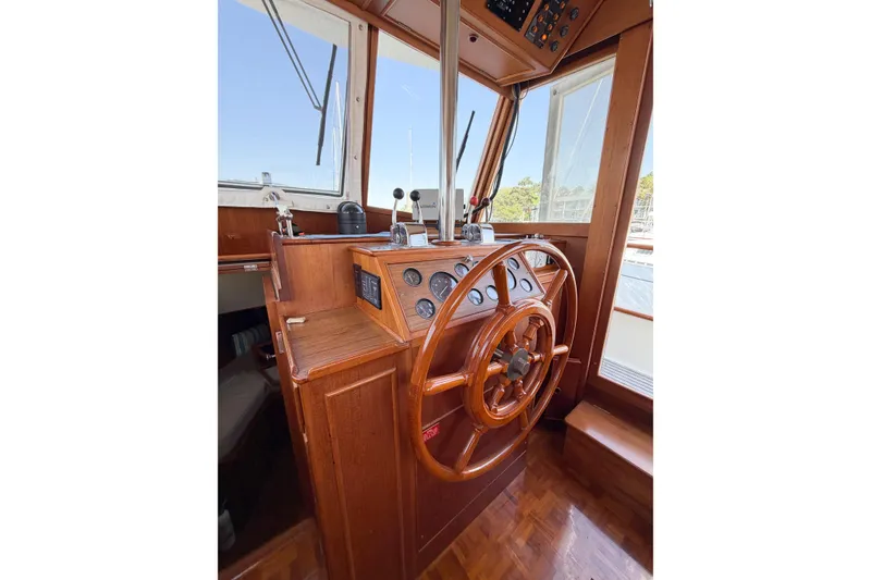 Slide: The Image of Helm of 1991 Grand Banks 36 Classic yacht with wooden steering wheel and control panel. - 33