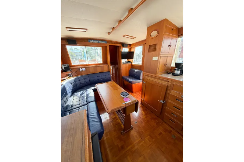 Slide: The Image of Interior of 1991 Grand Banks 36 Classic yacht with wooden furnishings and blue seating. - 37