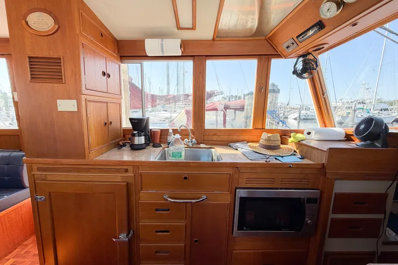 Slide: The Image of Interior of 1991 Grand Banks 36 Classic yacht with wooden cabinetry and marina view. - 38