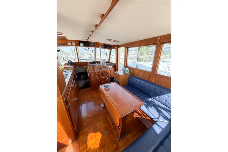 Slide: The Image of Interior of 1991 Grand Banks 36 Classic yacht with wooden helm and seating area. - 40