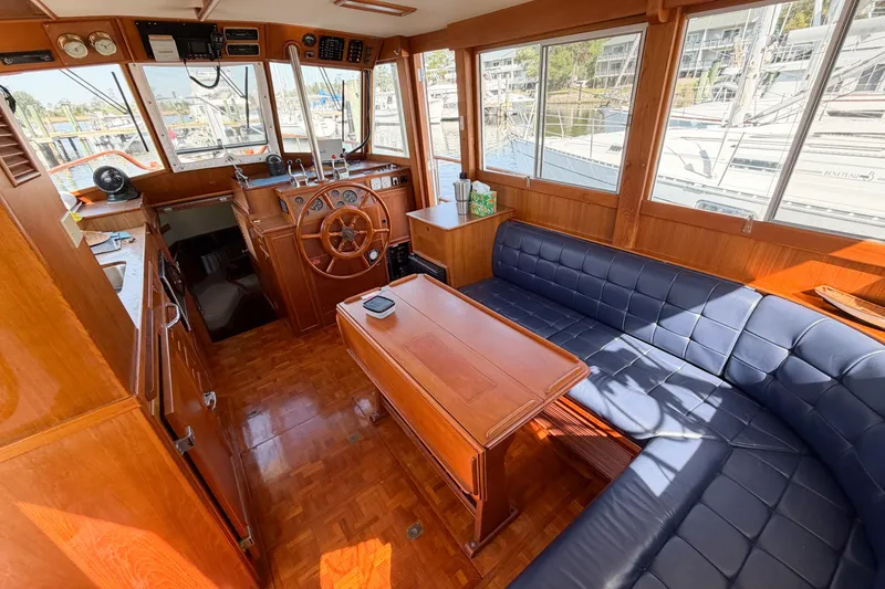 Slide: The Image of Interior of 1991 Grand Banks 36 Classic yacht with wooden furnishings and blue seating. - 41