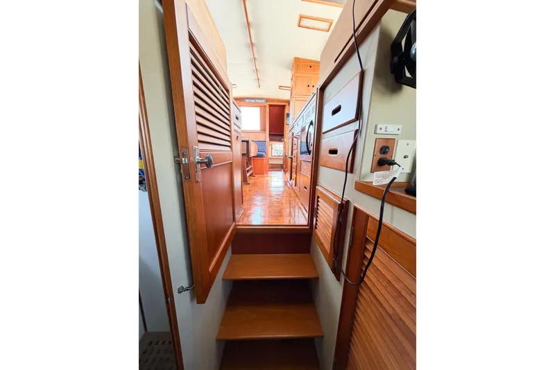 Slide: The Image of Interior view of 1991 Grand Banks 36 Classic yacht, showcasing wooden cabinetry and stairs. - 46