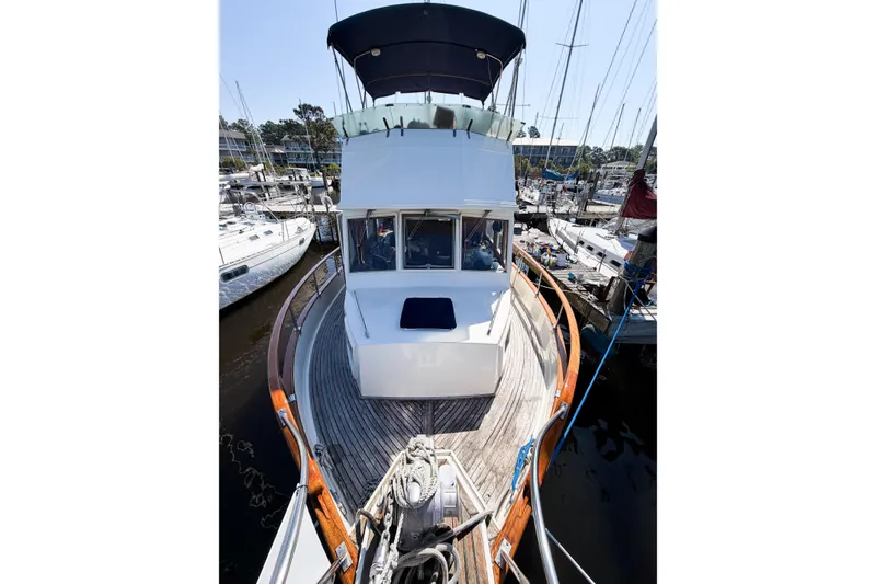 Slide: The Image of 1991 Grand Banks 36 Classic yacht docked at marina, showcasing elegant wooden deck and cabin. - 5