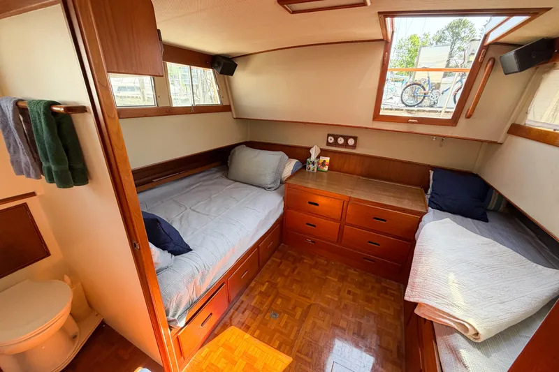 Slide: The Image of Cozy cabin interior of a 1991 Grand Banks 36 Classic yacht with twin beds and wooden cabinetry. - 56