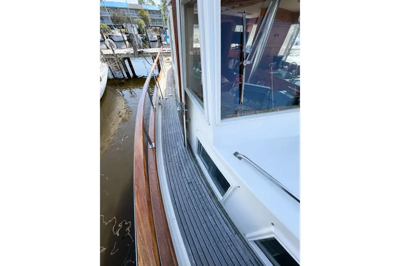 Slide: The Image of Side deck view of a 1991 Grand Banks 36 Classic yacht, showcasing teak woodwork. - 7