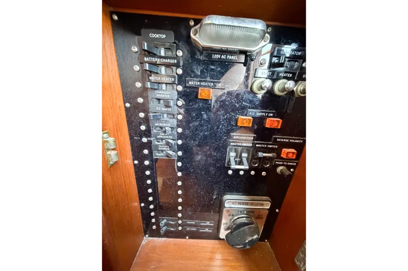 Slide: The Image of Electrical panel of a 1991 Grand Banks 36 Classic boat, featuring various switches and controls. - 72