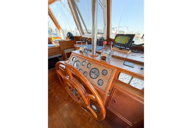Slide: The Image of Helm of 1991 Grand Banks 36 Classic yacht with wooden wheel and navigation instruments. - 77