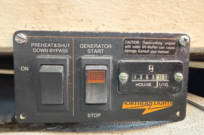 Slide: The Image of Control panel of a 1991 Grand Banks 36 Classic generator with hour meter and caution label. - 85