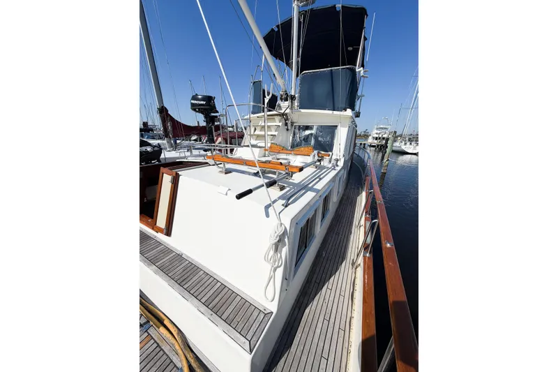 Slide: The Image of 1991 Grand Banks 36 Classic yacht docked, showcasing sleek design and wooden deck details. - 9