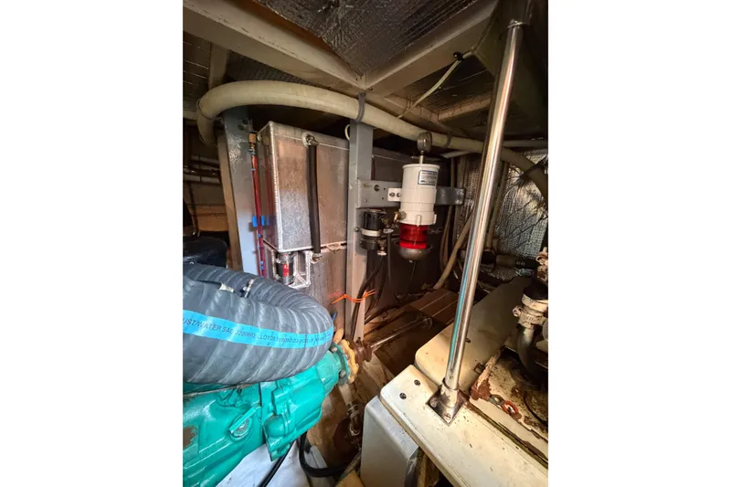 Slide: The Image of Engine room of 1991 Grand Banks 36 Classic, showcasing mechanical components and piping. - 95