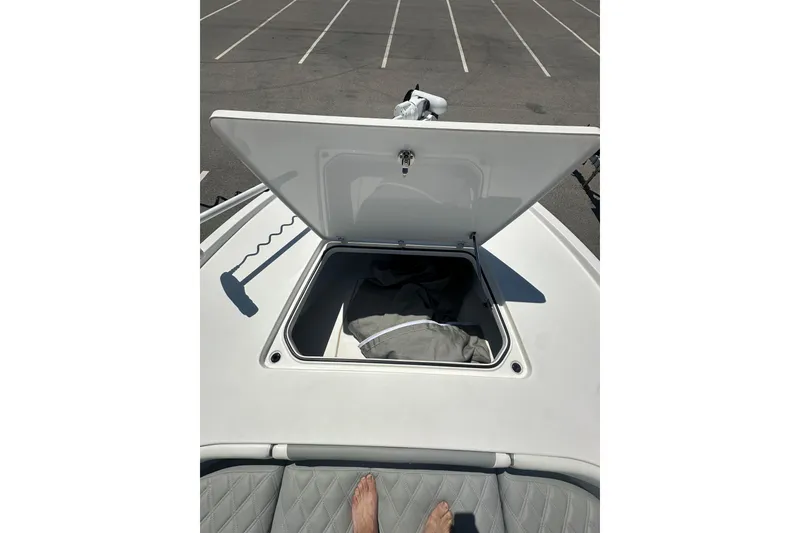 Slide: The Image of Open storage compartment on 2021 Caymas 28 HB boat, parked in an empty lot. - 16
