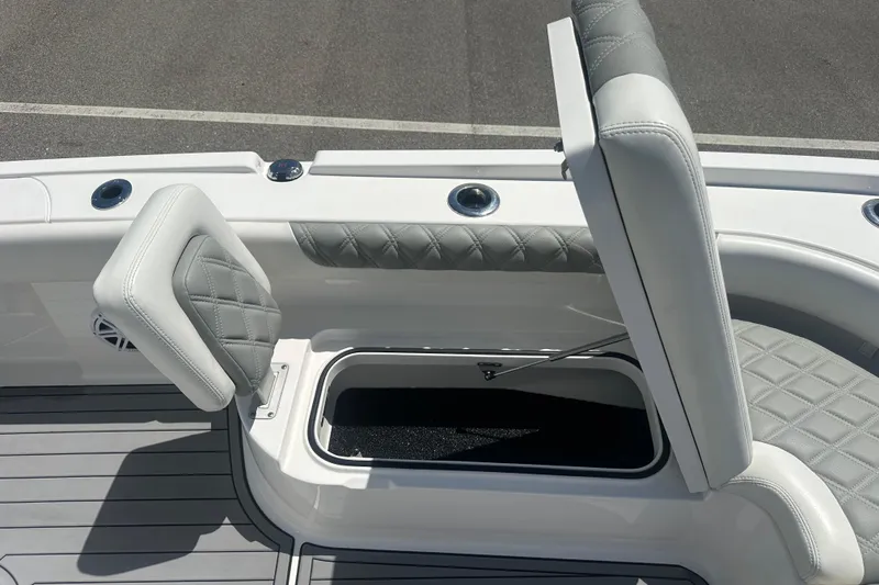 Slide: The Image of 2021 Caymas 28 HB boat with open storage compartment and cushioned seating. - 21