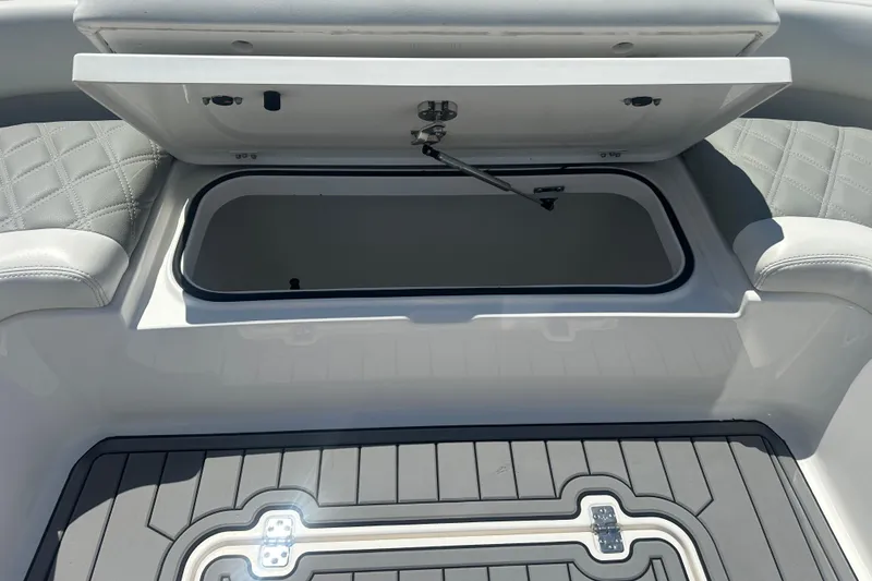Slide: The Image of Open storage compartment on 2021 Caymas 28 HB boat with cushioned seating. - 22