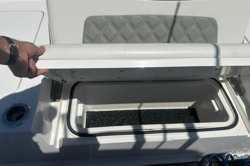 Slide: The Image of 2021 Caymas 28 HB boat storage compartment with cushioned seat and hand opening lid. - 25