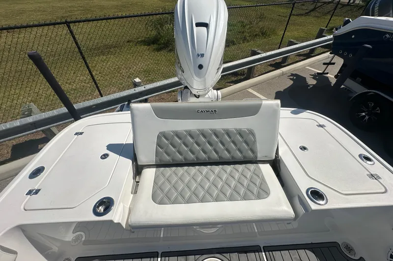 Slide: The Image of 2021 Caymas 28 HB boat with cushioned seating and outboard motor. - 30
