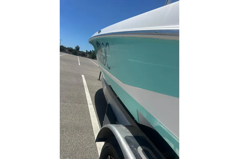 Slide: The Image of 2021 Caymas 28 HB boat on trailer, side view, teal and white color scheme. - 6