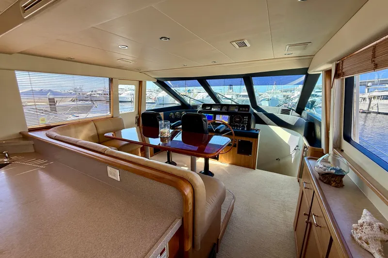 Slide: The Image of Outdoor seating area on a 2001 Pacific Mariner 65 Motoryacht, featuring wooden deck and table. - 10