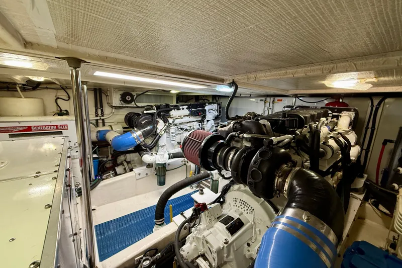 Slide: The Image of Engine room of 2001 Pacific Mariner 65 Motoryacht, featuring complex machinery and generator sets. - 55