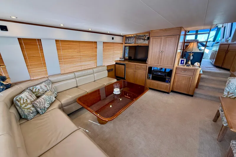 Slide: The Image of 2001 Pacific Mariner 65 Motoryacht docked near luxury resort buildings under a clear blue sky. - 6