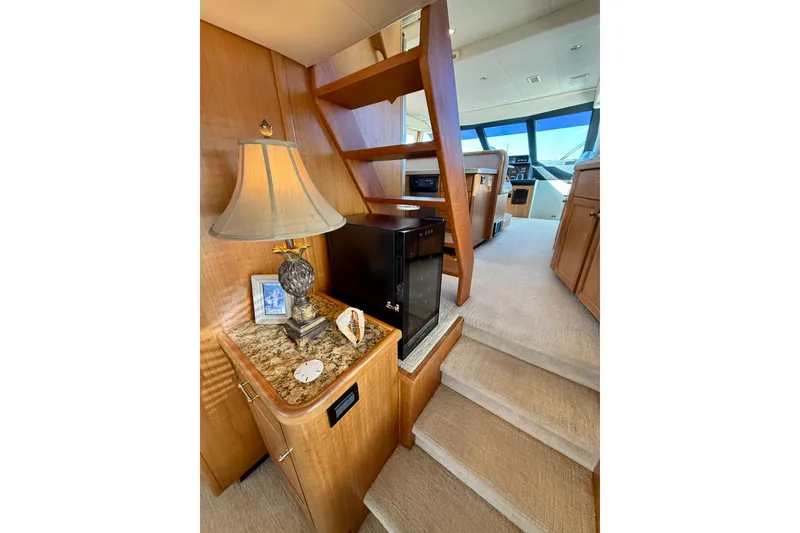 Slide: The Image of Outdoor seating area on a 2001 Pacific Mariner 65 Motoryacht, featuring a wooden table and cushioned bench. - 9