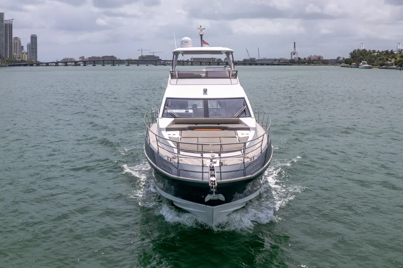Slide: The Image of Azimut 60 Fly 2023 yacht cruising on water, city skyline in background. - 5