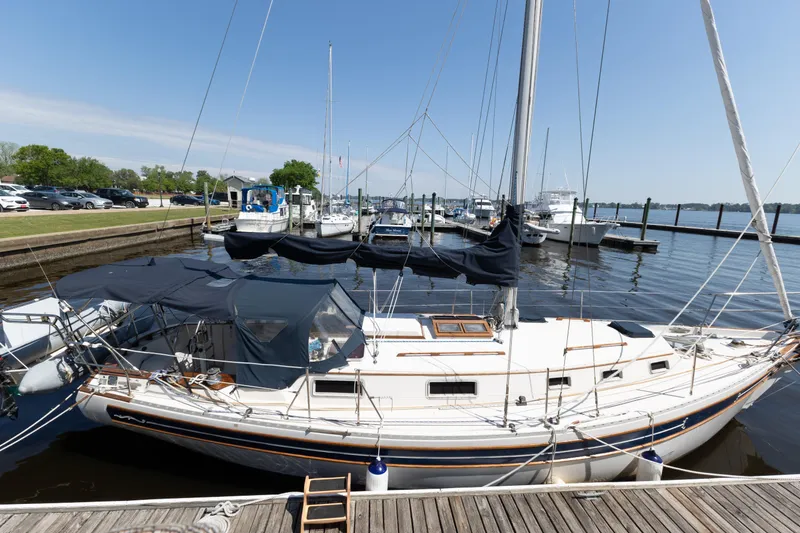 The Image of 1987 Bayfield 36 sailboat docked at a marina on a sunny day. - 1