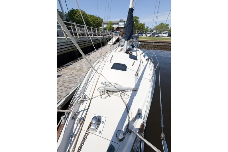 Slide: The Image of 1987 Bayfield 36 sailboat docked, showcasing deck and rigging details. - 12