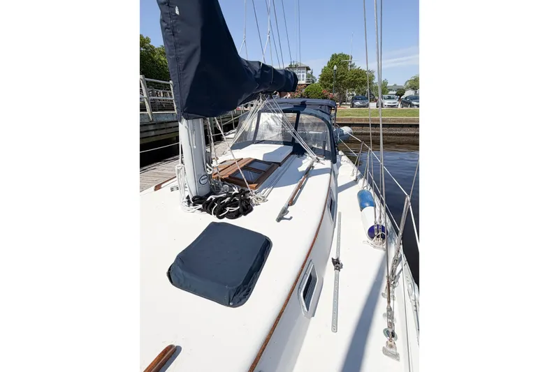Slide: The Image of 1987 Bayfield 36 sailboat docked, featuring a clean deck and covered sails. - 13