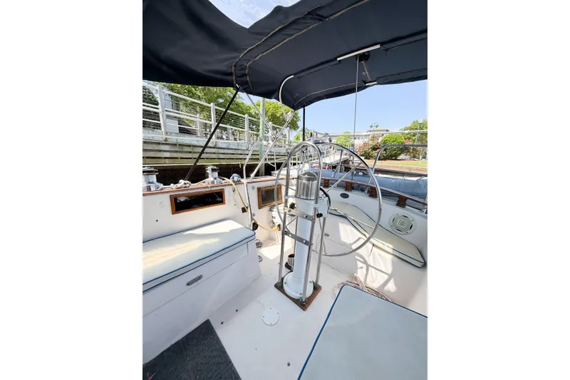 Slide: The Image of 1987 Bayfield 36 sailboat cockpit with steering wheel and seating under canopy. - 20