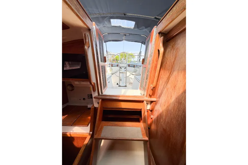 Slide: The Image of Interior view of 1987 Bayfield 36 sailboat, showcasing wooden steps and cabin entrance. - 26