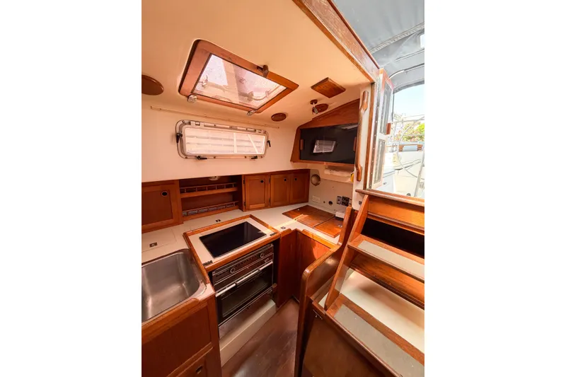 Slide: The Image of 1987 Bayfield 36 yacht interior with wooden cabinetry, stove, and sink. - 27