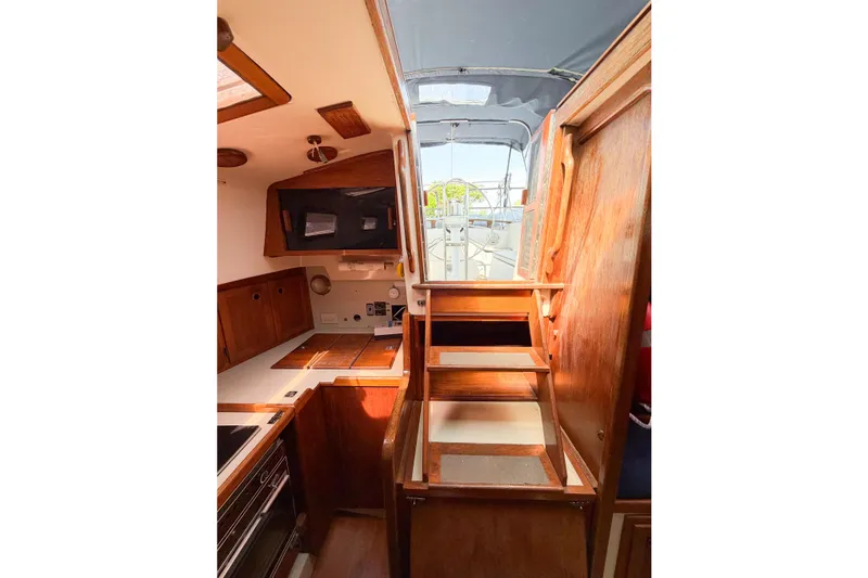 Slide: The Image of Interior view of 1987 Bayfield 36 sailboat with wooden cabinetry and steps. - 28