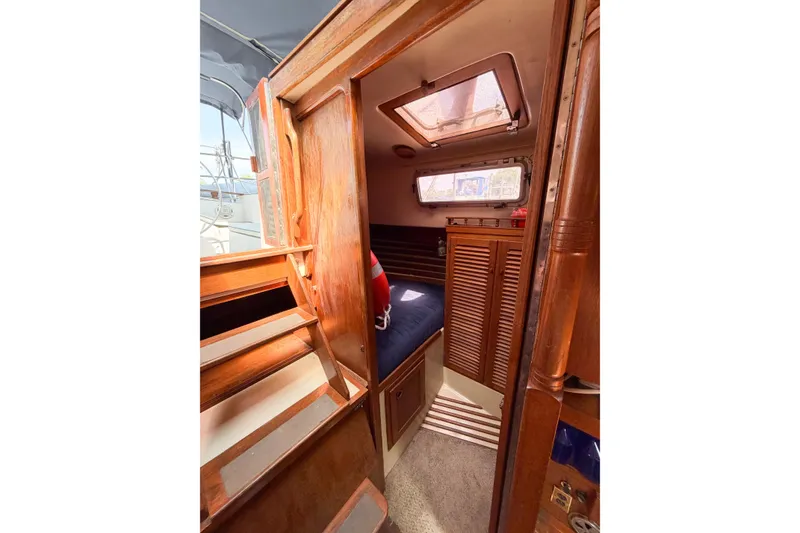 Slide: The Image of Interior cabin of a 1987 Bayfield 36 sailboat with wooden finishes and cozy sleeping area. - 29