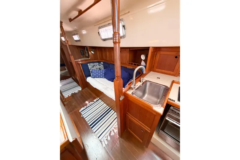 Slide: The Image of Interior of 1987 Bayfield 36 sailboat with wooden cabinetry and cozy seating area. - 32