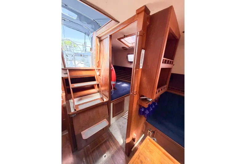 Slide: The Image of Interior of 1987 Bayfield 36 sailboat with wooden cabinetry and blue seating. - 34