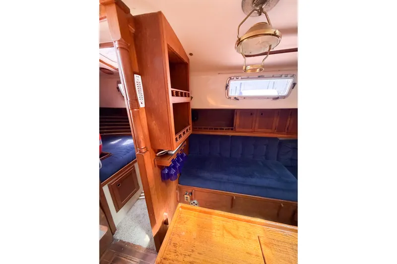 Slide: The Image of Interior of 1987 Bayfield 36 sailboat with wooden cabinetry and blue cushioned seating. - 35
