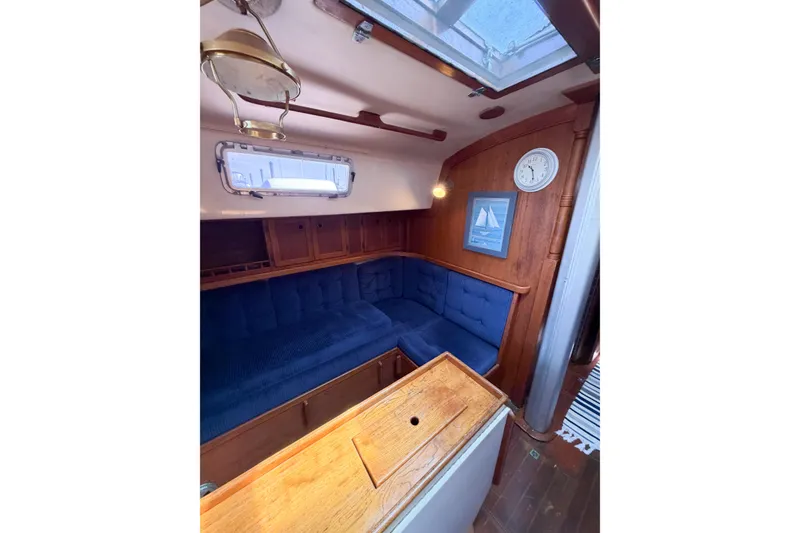 Slide: The Image of Interior of a 1987 Bayfield 36 sailboat with blue seating and wooden accents. - 36