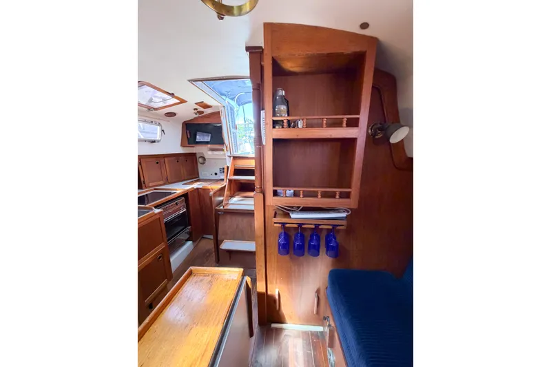 Slide: The Image of Interior of 1987 Bayfield 36 sailboat with wooden cabinetry and blue accents. - 39