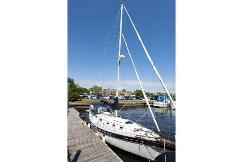 Slide: The Image of 1987 Bayfield 36 sailboat docked at a marina under clear blue skies. - 4