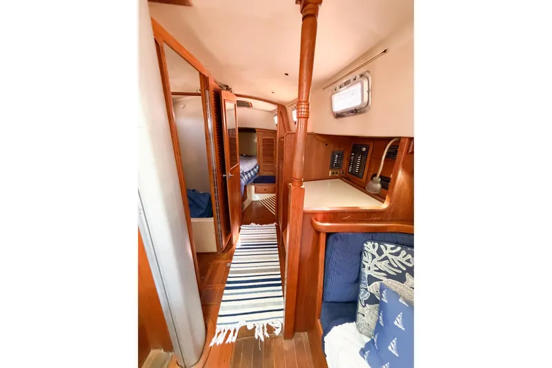 Slide: The Image of Interior of a 1987 Bayfield 36 sailboat, featuring wood paneling and cozy seating. - 43