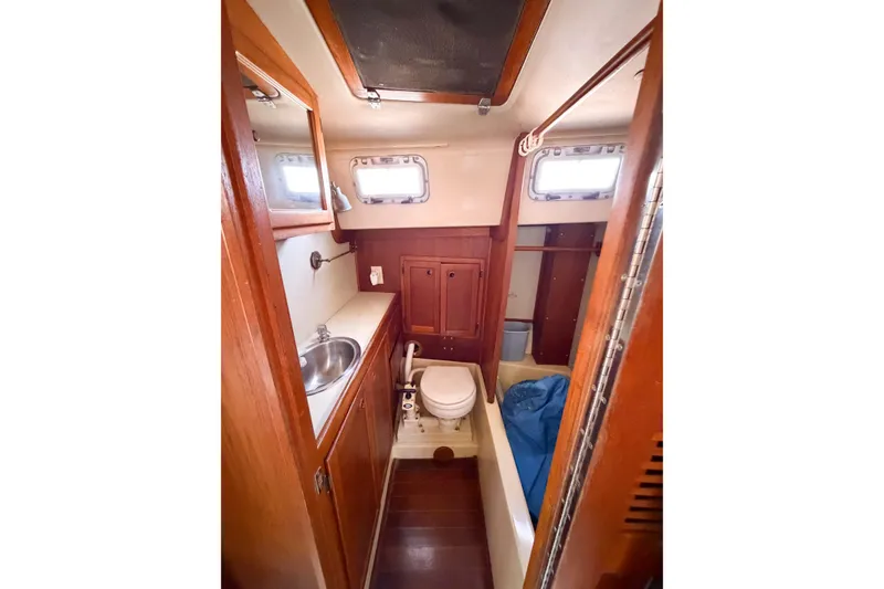 Slide: The Image of Interior of 1987 Bayfield 36 sailboat bathroom with wooden cabinetry and compact design. - 44