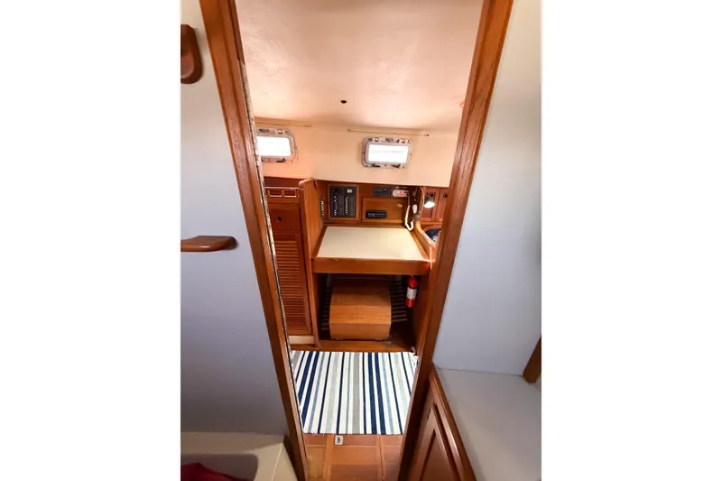 Slide: The Image of Interior view of a 1987 Bayfield 36 sailboat cabin with wooden finishes and striped rug. - 47