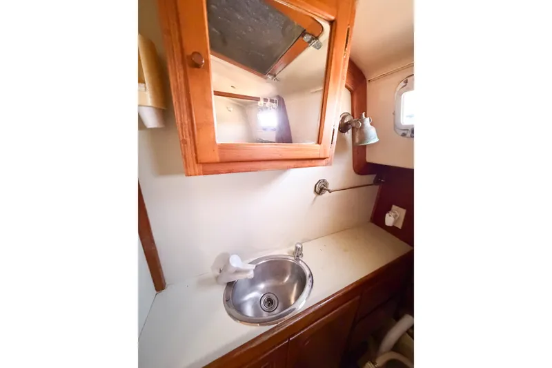 Slide: The Image of 1987 Bayfield 36 yacht bathroom with sink, mirror, and wooden cabinetry. - 48