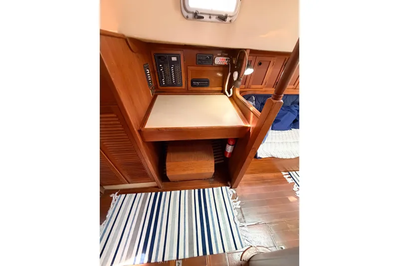 Slide: The Image of 1987 Bayfield 36 sailboat interior with navigation station and striped rug. - 49