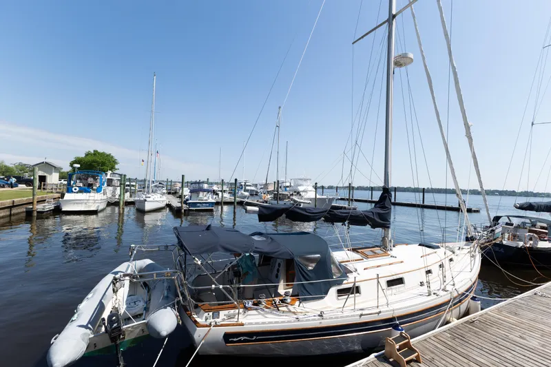 Slide: The Image of 1987 Bayfield 36 sailboat docked at a marina with other boats under a clear blue sky. - 5