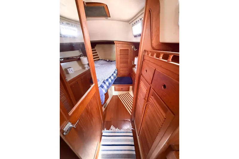 Slide: The Image of Cozy 1987 Bayfield 36 yacht cabin with wooden interior and striped rug. - 50